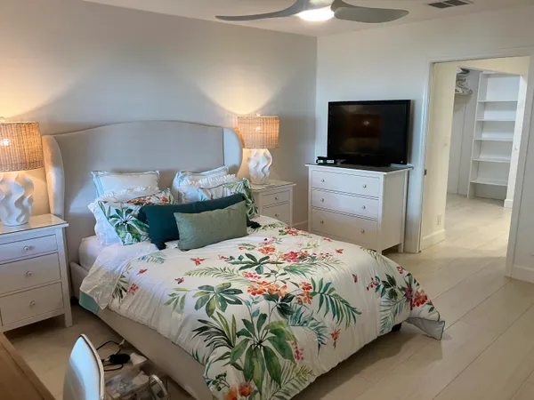 a bedroom with a bed and a flat screen tv