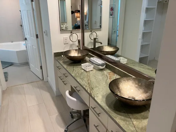 a bathroom with a granite countertop sink a toilet and a mirror