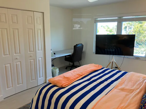 a bedroom with a bed and a flat screen tv