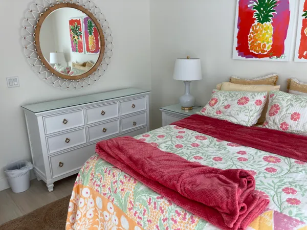 a bedroom with a bed and painting on the wall