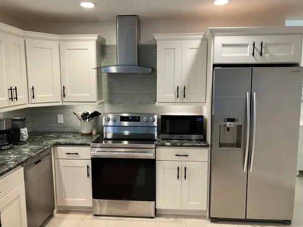 a kitchen with stainless steel appliances granite countertop a refrigerator stove and cabinets