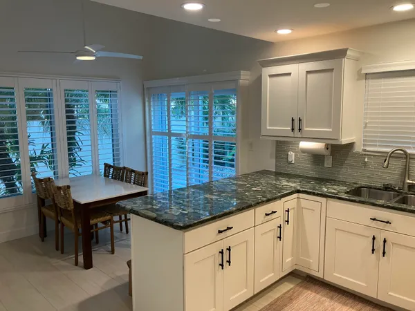 a kitchen with granite countertop a sink a center island and cabinets