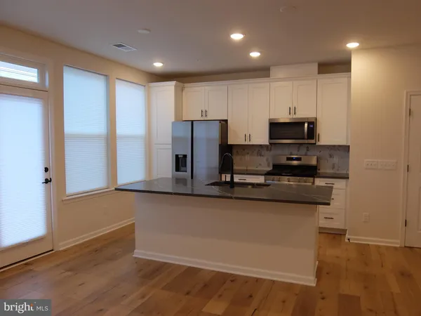 a kitchen with stainless steel appliances granite countertop a refrigerator and a stove top oven