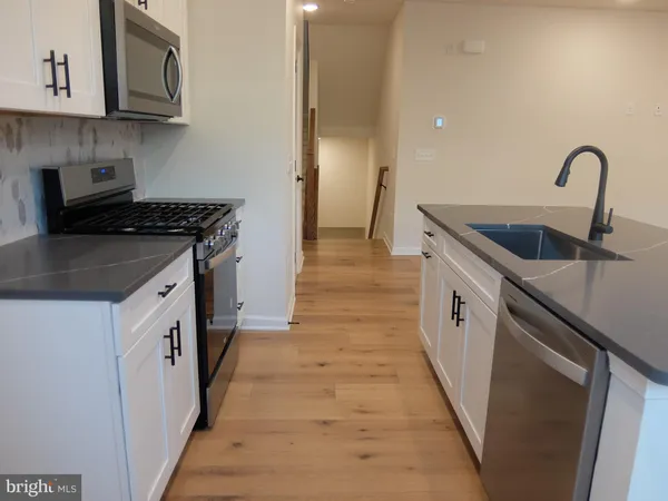 a kitchen with stainless steel appliances granite countertop a sink and a stove top oven