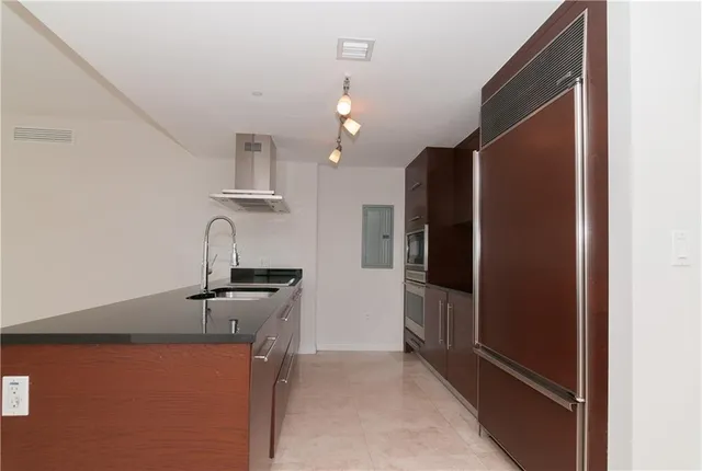 a room with lots of white furniture and a potted plant