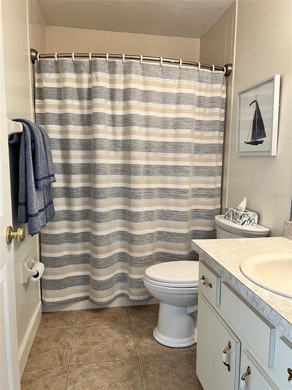 12595 Southeast Sunset Harbor Road Weirsdale, FL 32195 - Photo 9 of 25 a bathroom with a sink a toilet and shower curtain