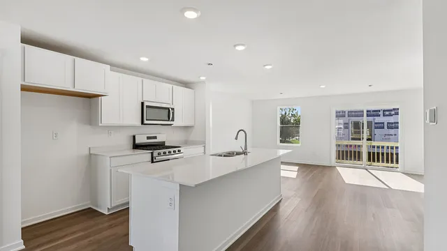 a kitchen with stainless steel appliances granite countertop a sink stove and cabinets