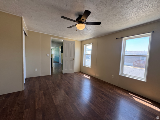 2491 Highway 89, Unit 315 Pleasant View, UT 84404 - Photo 16 of 34 Spacious interior room featuring rich wood-finish flooring, a ceiling fan with integrated lighting, and two windows providing natural illumination