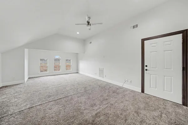 an empty room with a ceiling fan and window