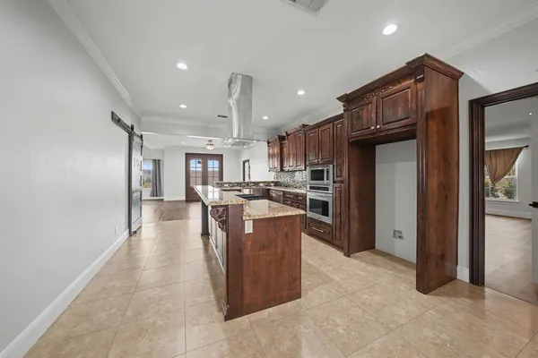 a kitchen with stainless steel appliances kitchen island granite countertop a refrigerator and a sink
