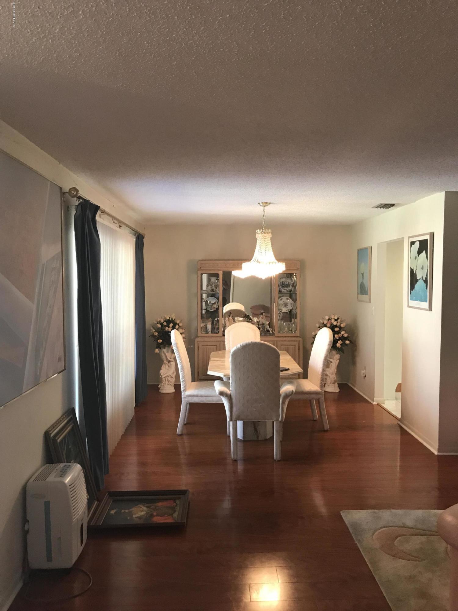 1350 Meadowbrook Road Northeast Palm Bay, FL 32905 - Photo 30 of 55 a view of a dining room with furniture and wooden floor