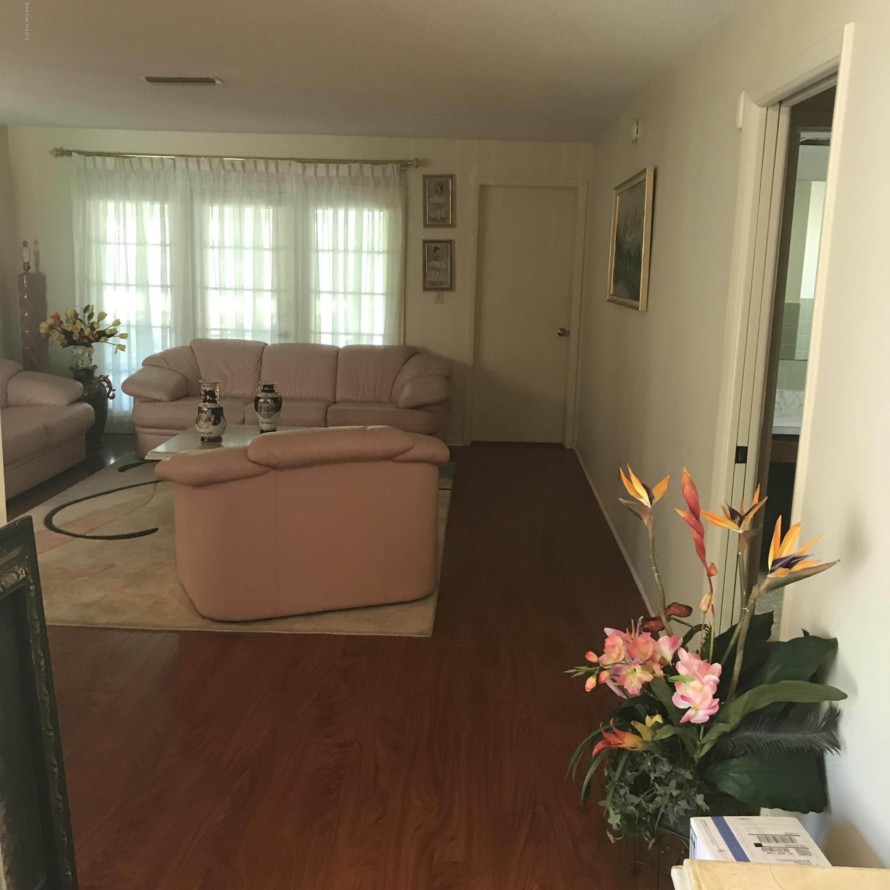 1350 Meadowbrook Road Northeast Palm Bay, FL 32905 - Photo 32 of 55 a living room with furniture and flowers