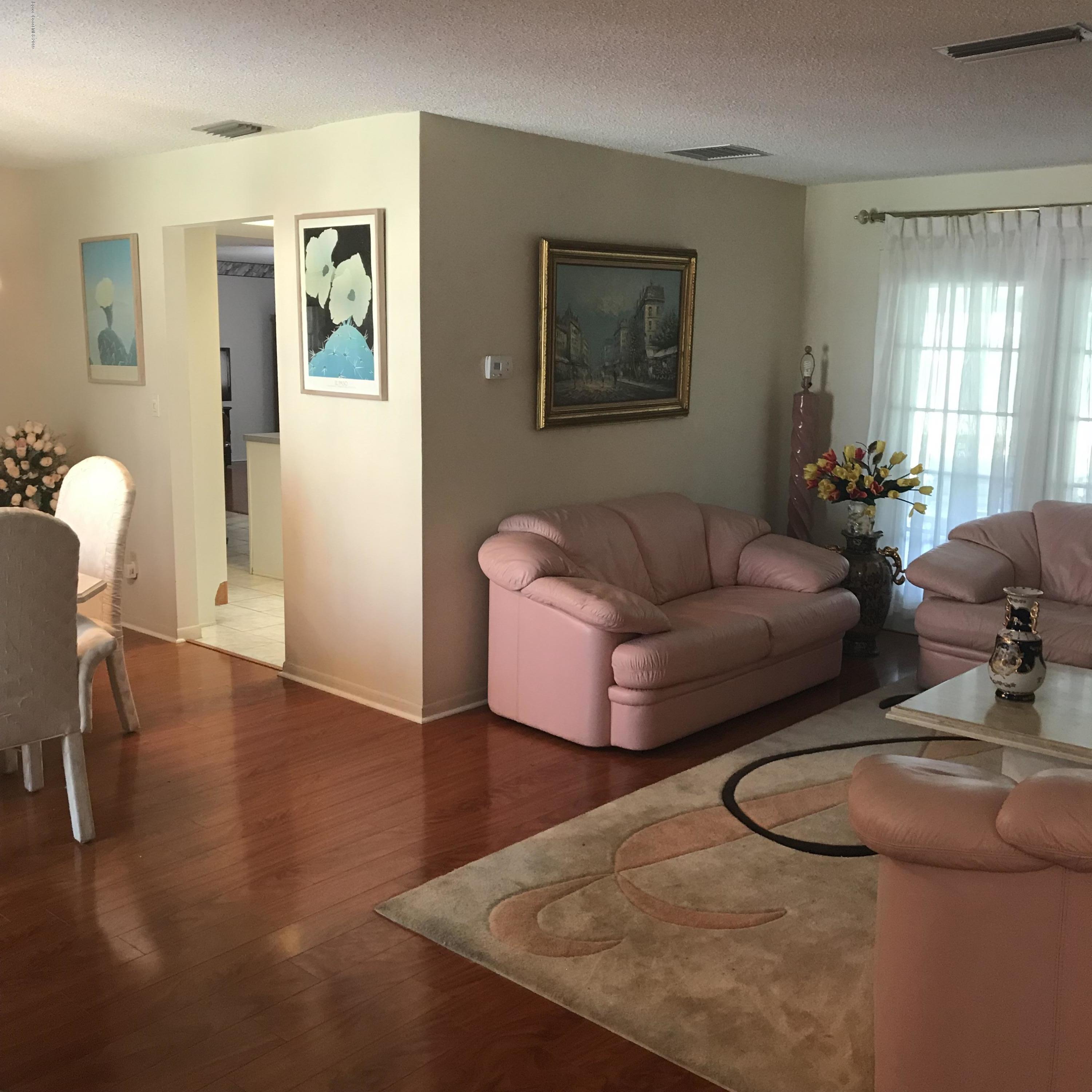 1350 Meadowbrook Road Northeast Palm Bay, FL 32905 - Photo 33 of 55 a living room with furniture and wooden floor