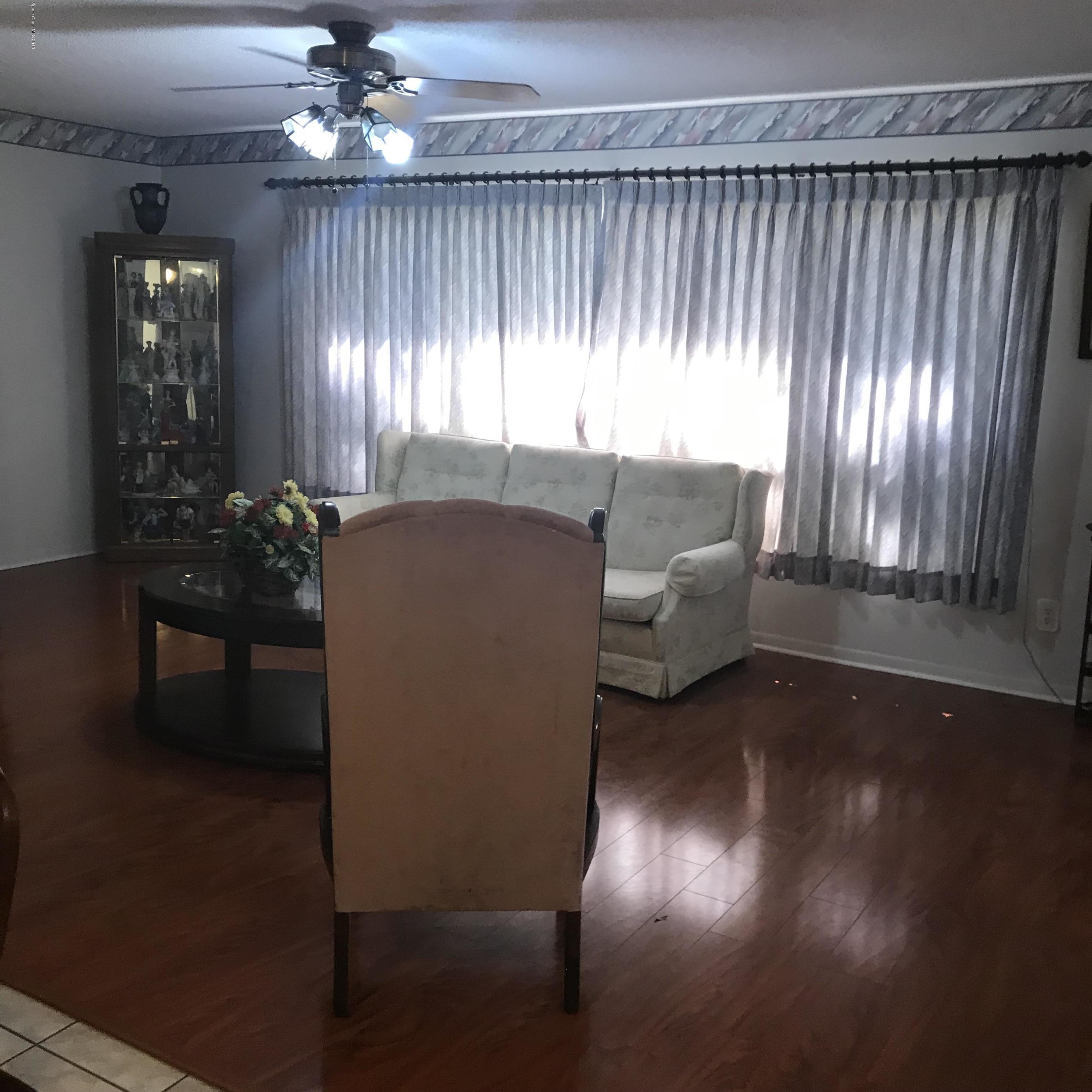 1350 Meadowbrook Road Northeast Palm Bay, FL 32905 - Photo 44 of 55 a living room with furniture and a chandelier