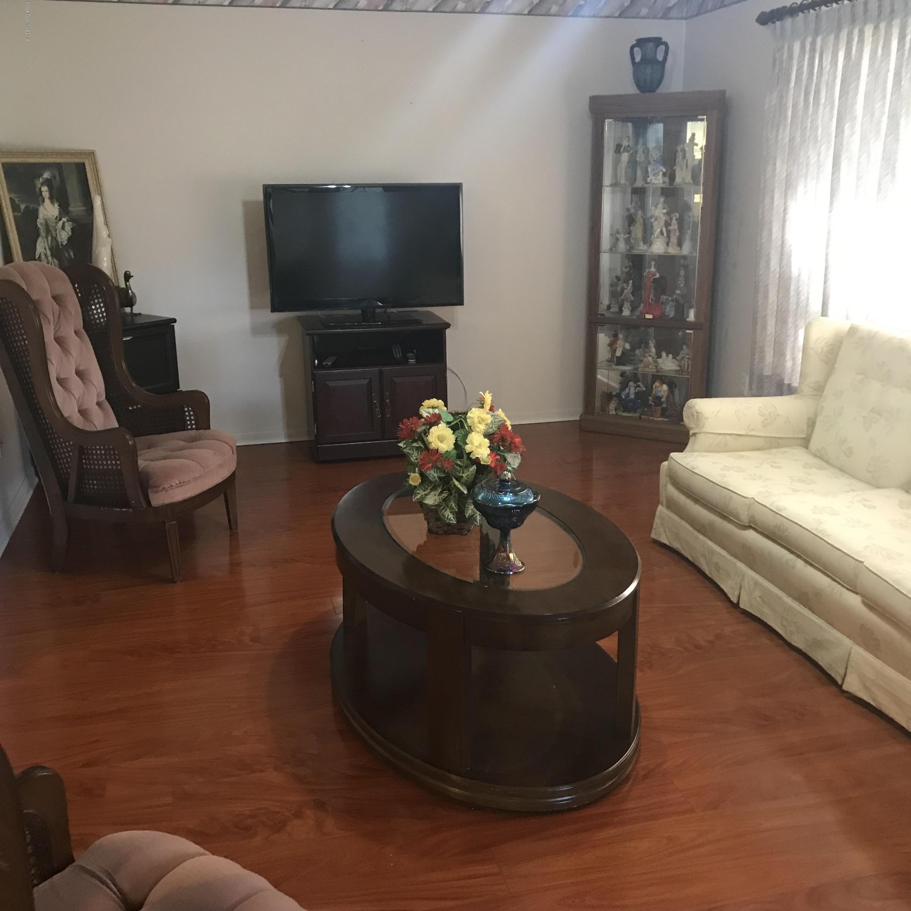 1350 Meadowbrook Road Northeast Palm Bay, FL 32905 - Photo 48 of 55 a living room with furniture and a flat screen tv