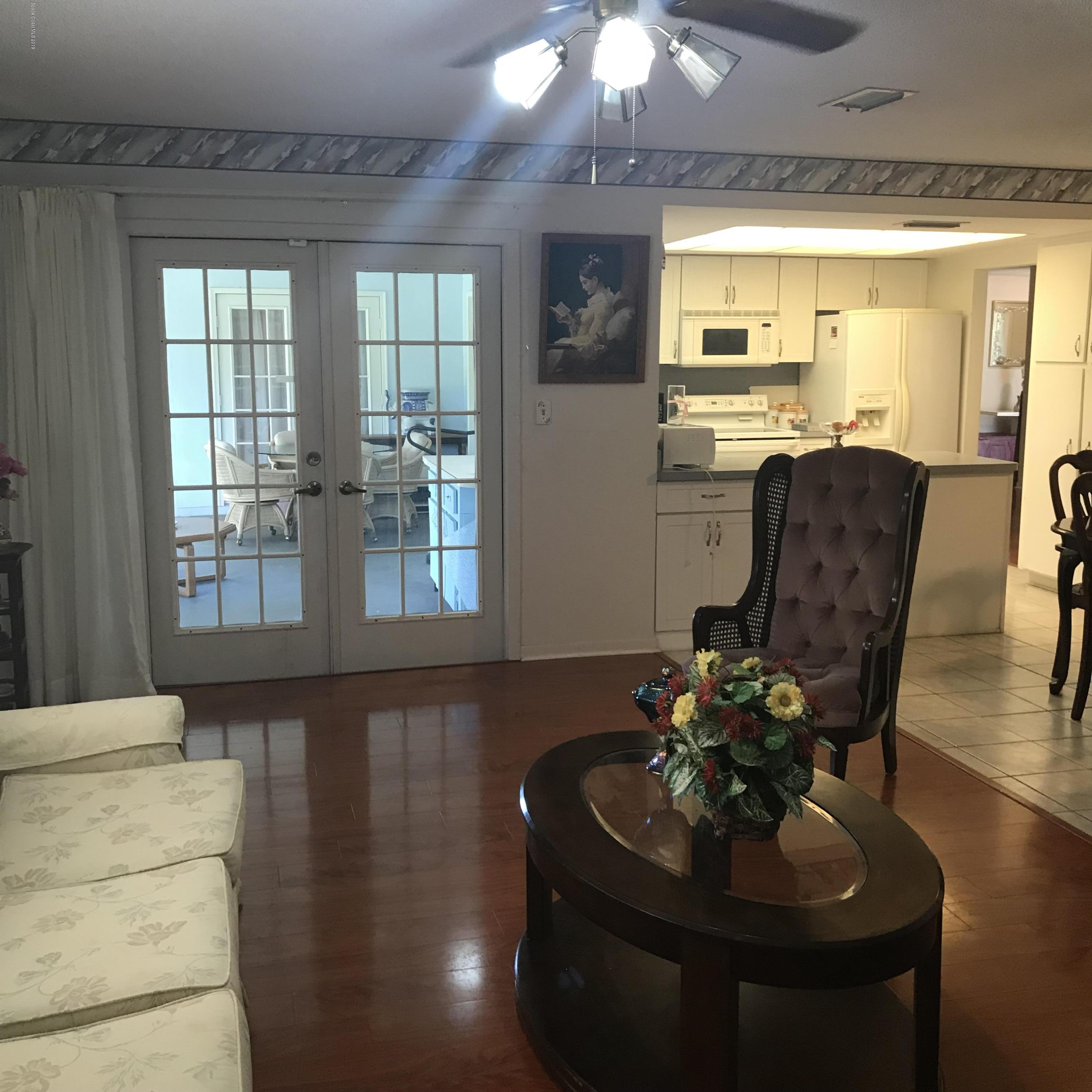 1350 Meadowbrook Road Northeast Palm Bay, FL 32905 - Photo 49 of 55 a living room with furniture and a chandelier