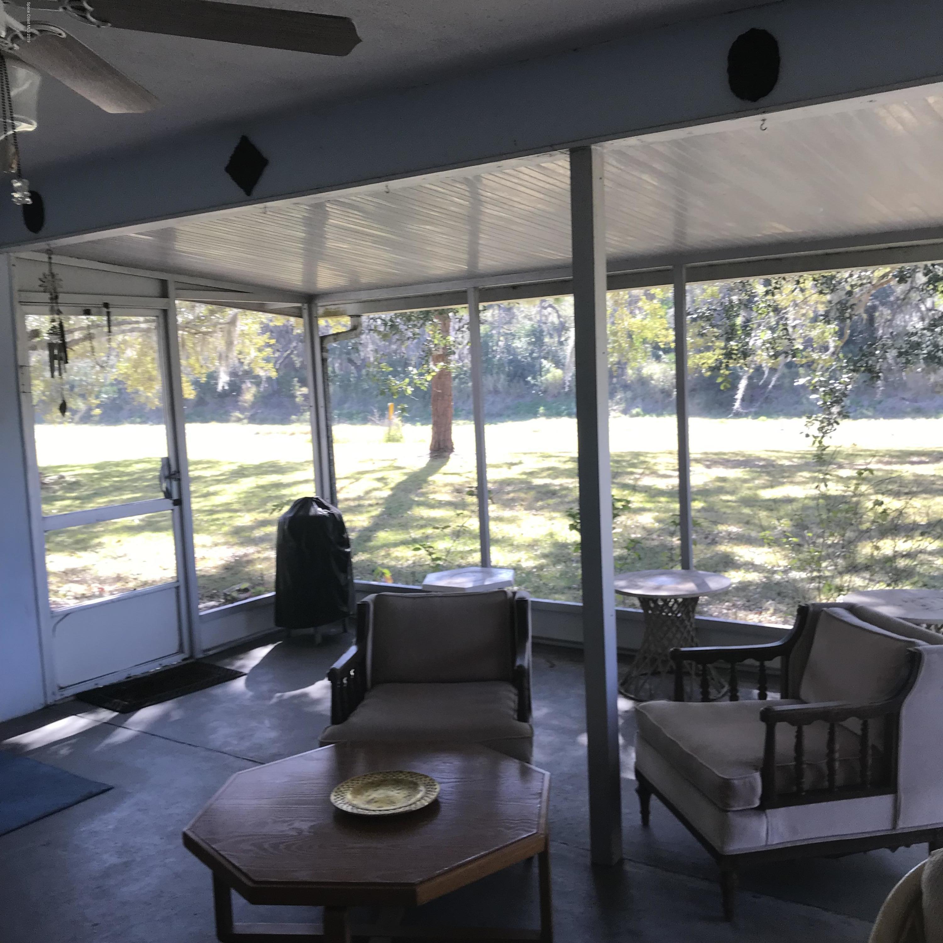 1350 Meadowbrook Road Northeast Palm Bay, FL 32905 - Photo 53 of 55 a living room with furniture and floor to ceiling windows
