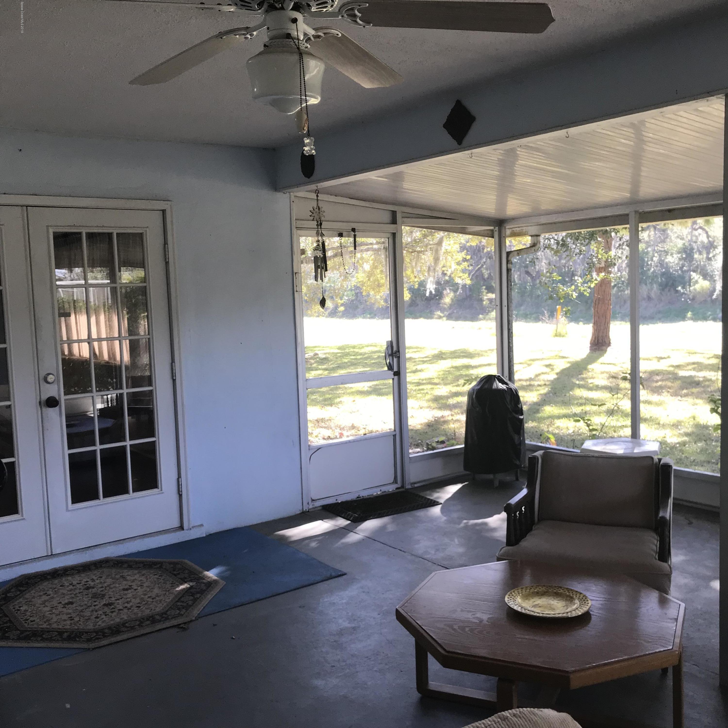 1350 Meadowbrook Road Northeast Palm Bay, FL 32905 - Photo 54 of 55 a living room with furniture and a floor to ceiling window