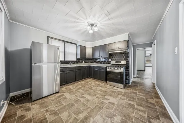 a kitchen with granite countertop a refrigerator stove and microwave