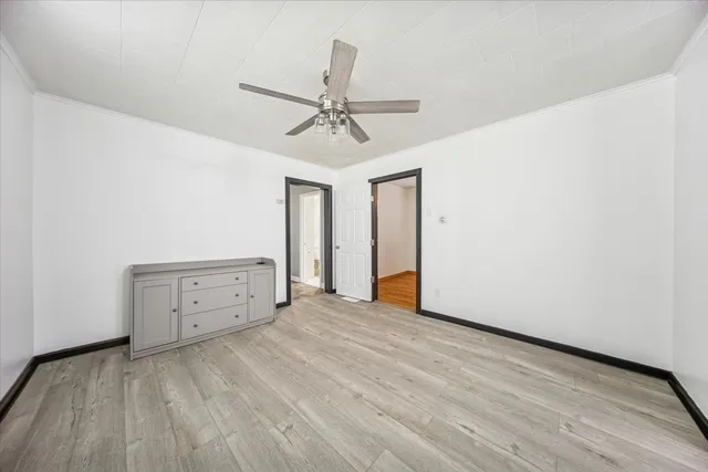 a view of an empty room with window and a ceiling fan