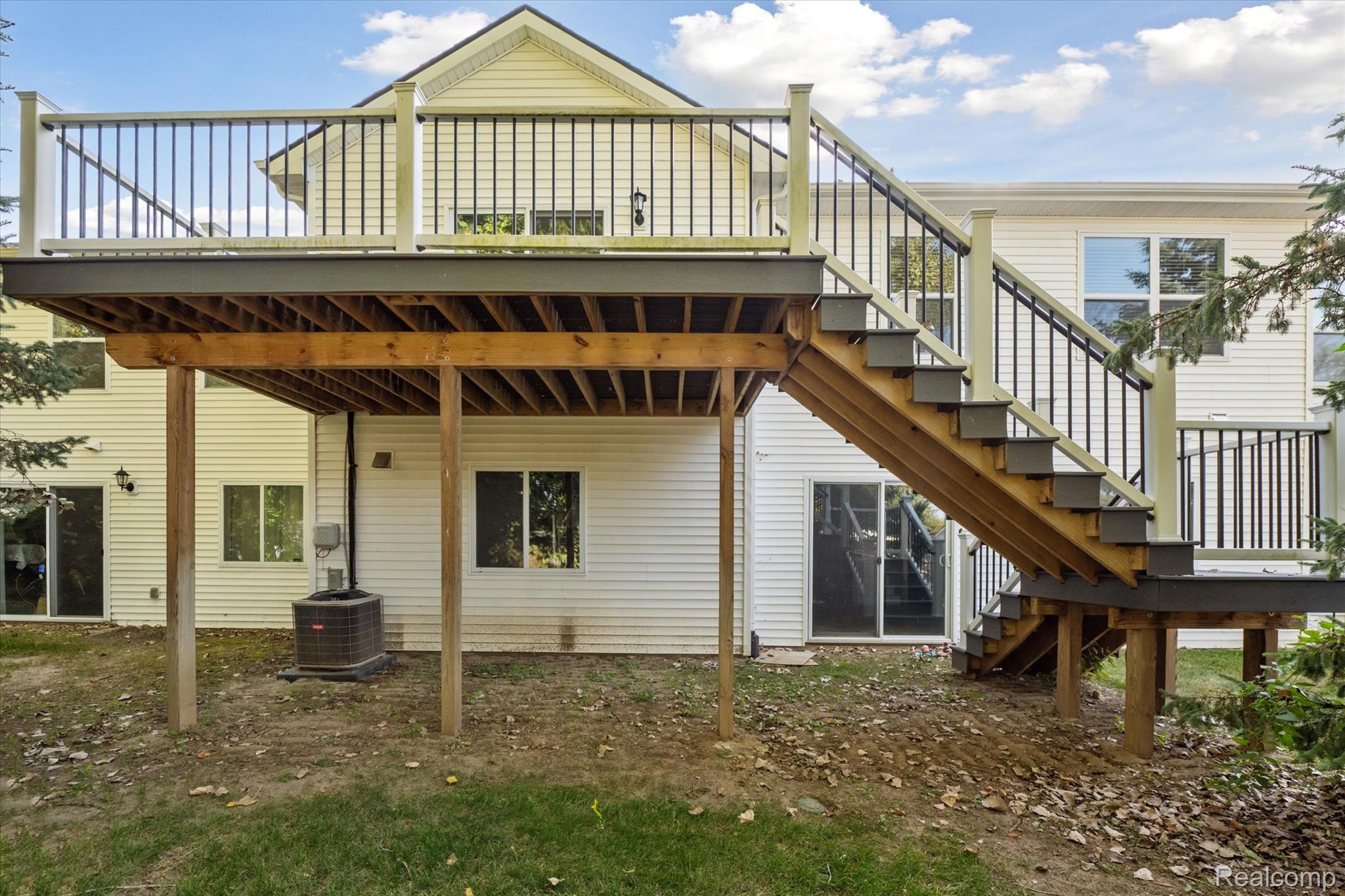 816 Nelson's Ridge Drive Howell, MI 48843 - Photo 25 of 36 Large composite deck with stairs to the backyard, perfect for outdoor entertaining and relaxation.