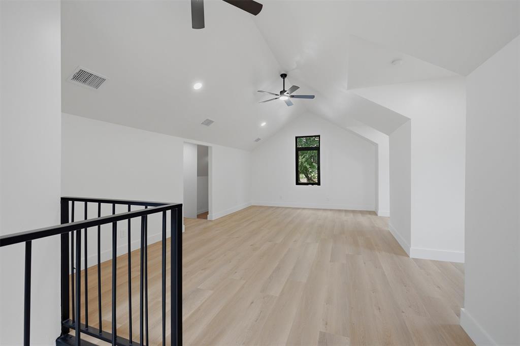 410 Arkansas Road Sadler, TX 76264 - Photo 27 of 40 Expansive loft space featuring vaulted ceilings, recessed lighting, and wood-finish flooring