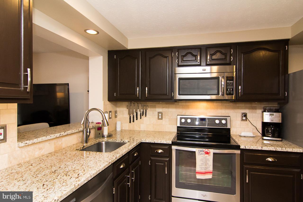 4122 Maple Path Circle, Unit 55 Baltimore, MD 21236 - Photo 11 of 27 a kitchen with stainless steel appliances granite countertop a stove microwave and sink