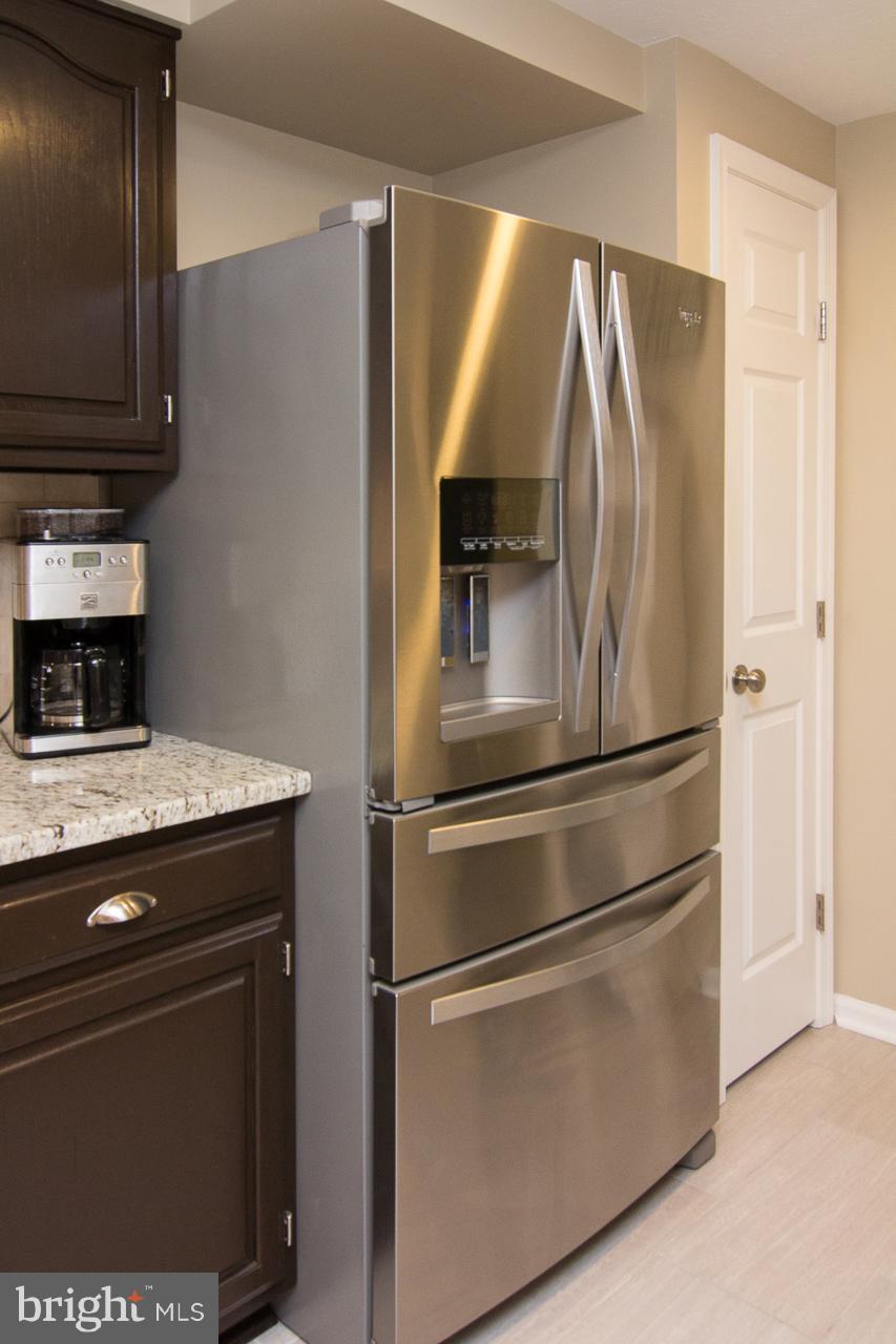 4122 Maple Path Circle, Unit 55 Baltimore, MD 21236 - Photo 12 of 27 a metallic refrigerator freezer sitting in a kitchen
