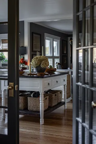 a dining hall with stainless steel appliances a dining table and chairs with wooden floor