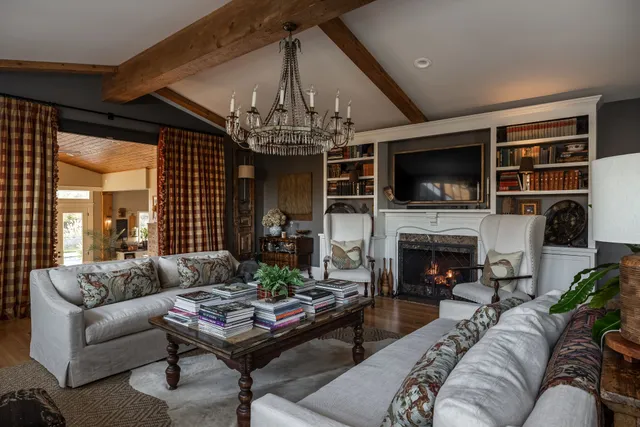a living room with fireplace furniture and a chandelier