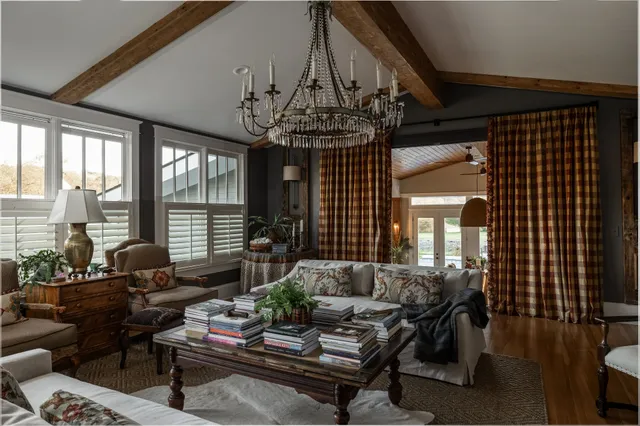 a spacious bedroom with a bed a mirror on the dresser and a fireplace