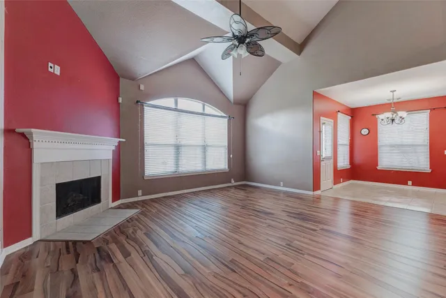 a view of empty room with wooden floor fireplace and fan