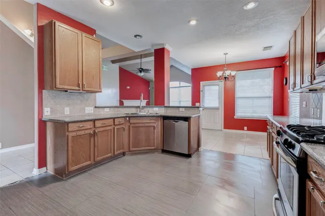 a kitchen with stainless steel appliances granite countertop a stove a sink and a microwave