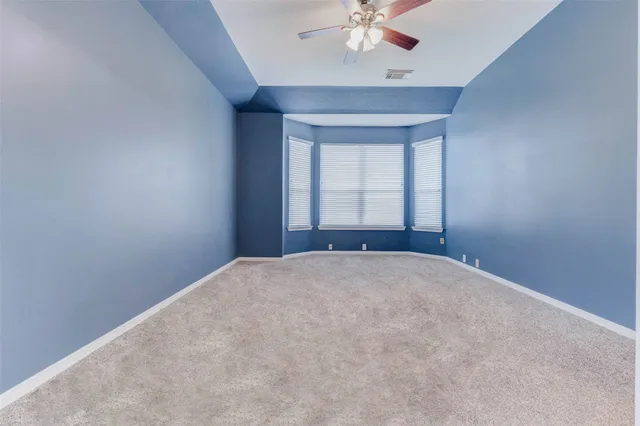 an empty room with a chandelier fan