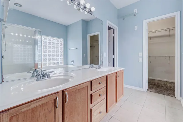a bathroom with a granite countertop sink a large mirror and a shower