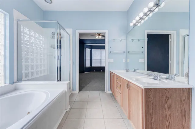 a spacious bathroom with a bathtub sink and mirror