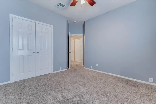 a view of an empty room and a ceiling fan
