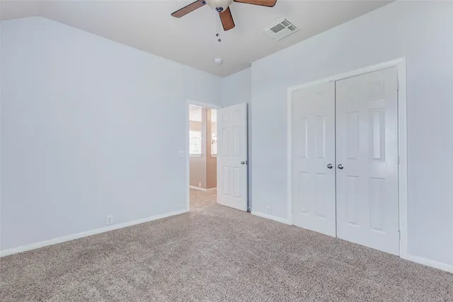 a view of an empty room and a ceiling fan window