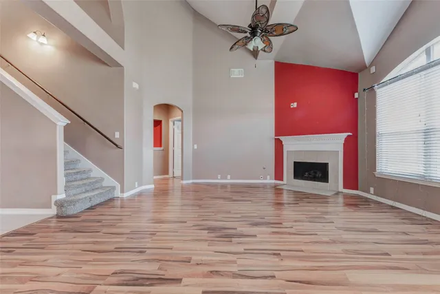 a view of empty room with fireplace and wooden floor