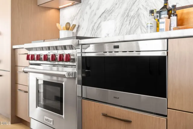 a living room with furniture large windows and wooden floor