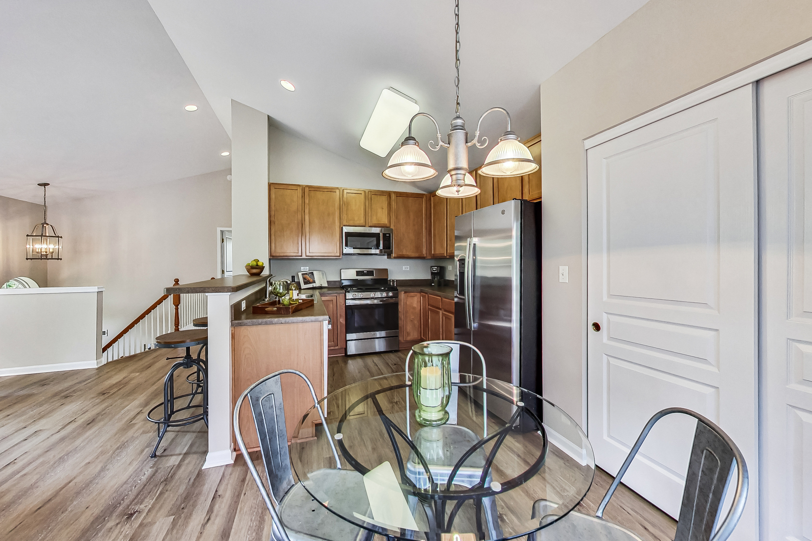 1052 Reserve Drive Elgin, IL 60123 - Photo 17 of 40 a view of a dining room with furniture a chandelier and wooden floor