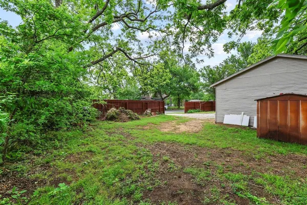 a view of a house with backyard and a tree