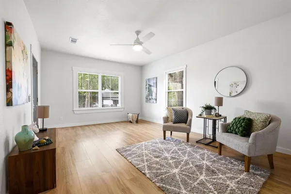 a living room with furniture and wooden floor