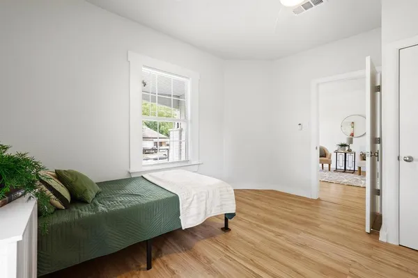 a bedroom with a bed and wooden floor