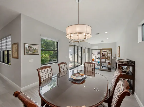 a view of a dining room with furniture a chandelier and wooden floor