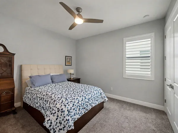 a bedroom with a bed and a ceiling fan