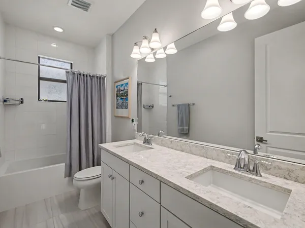 a bathroom with a granite countertop sink a toilet and a large mirror