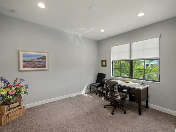 a view of a workspace with furniture and a window
