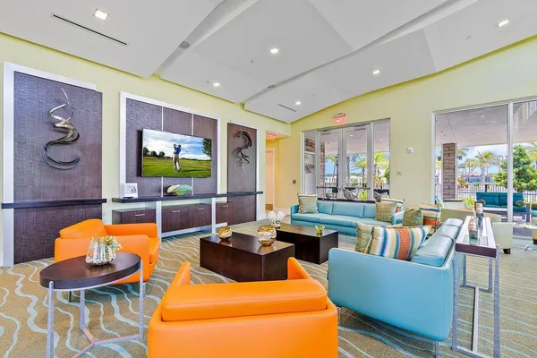 a living room with furniture a flat screen tv and a table