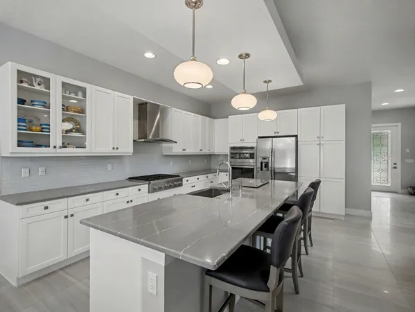 a kitchen with a table chairs microwave and cabinets